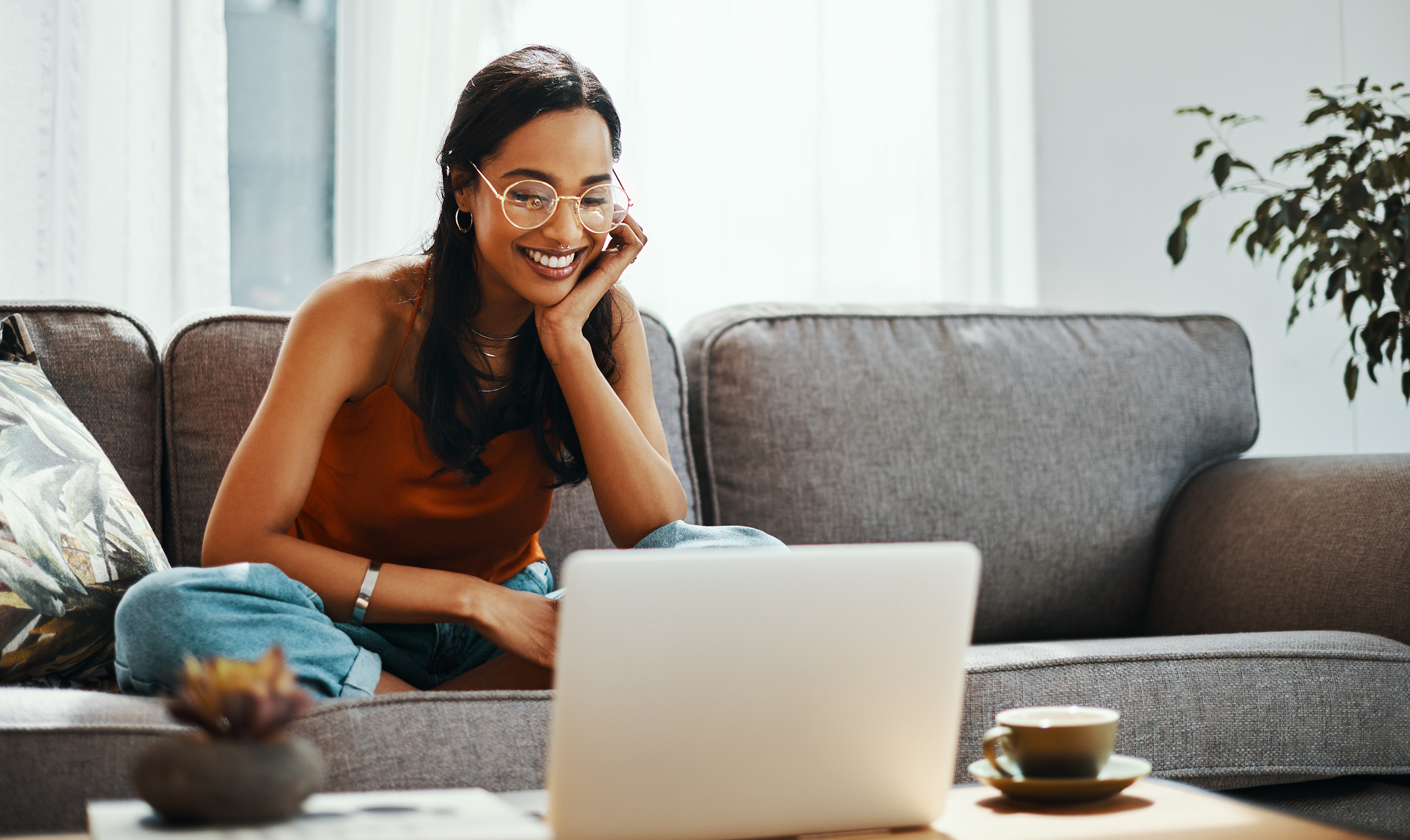 Can You Be Too Young to Buy a House? Shot of a young woman using a laptop on the sofa at home