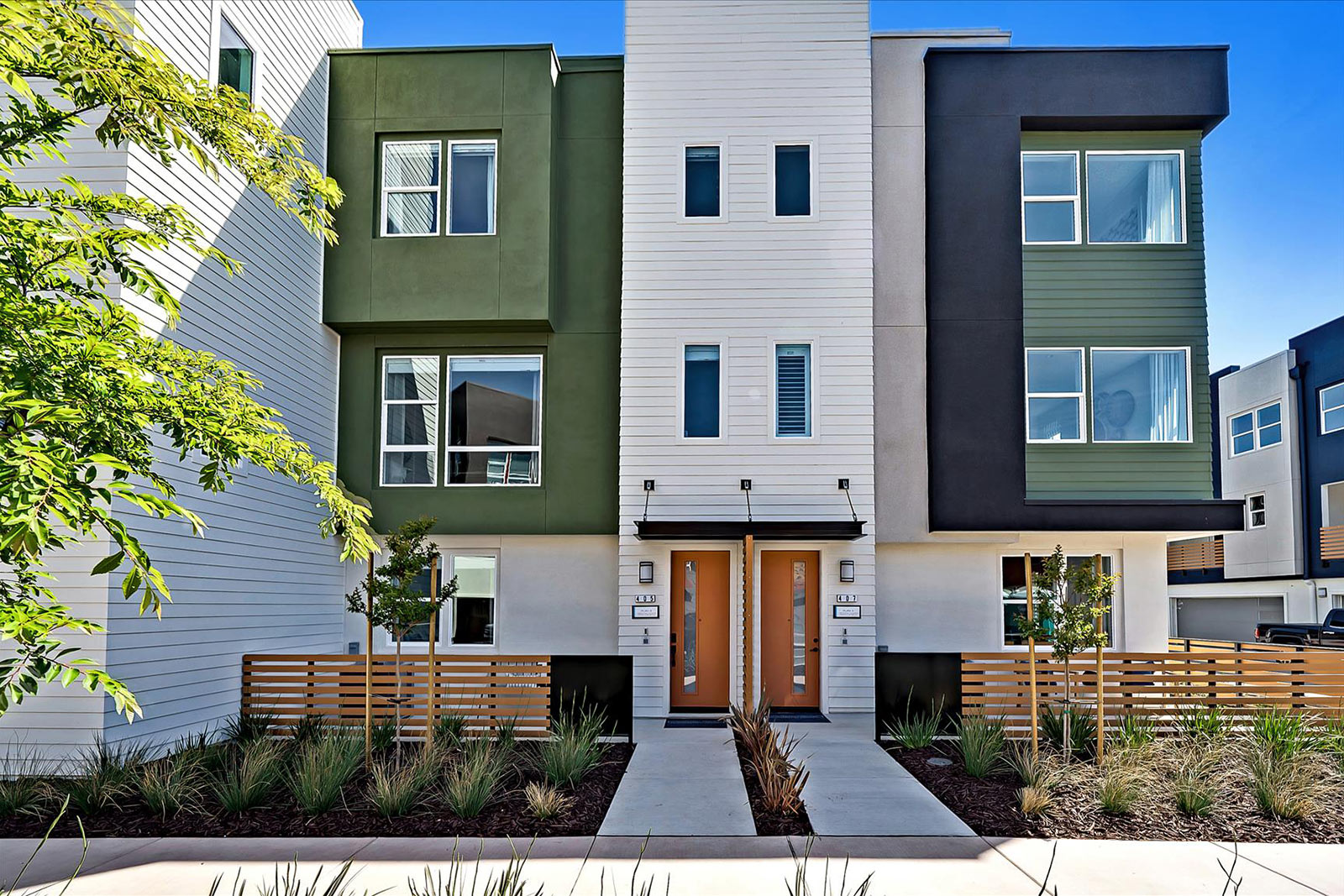 Unique, modern townhomes by SummerHill Homes featuring vibrant exterior colors, distinctive architecture, and inviting entrances.