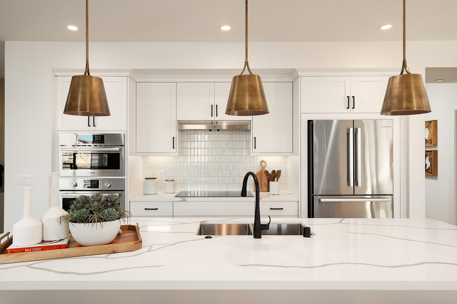 Modern kitchen by SummerHill Homes with stainless steel appliances, sleek cabinetry, and a stylish center island.